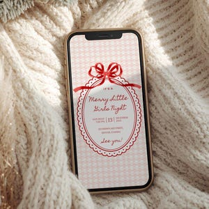 This is a lifestyle image mockup of a soft, woven, cream colored sweater. In the center of the sweater is a phone with a Christmas party invitation on the screen. The template is primarily red and white. The template is girly and cute, gingham background, red bow, white scallop lace as the border for the font.