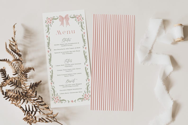 May include: A wedding menu card with a floral and bow design, featuring a menu of starters, entrees, and desserts. A second card with pink and white vertical stripes is next to it. White ribbon and a spool are also in the image.