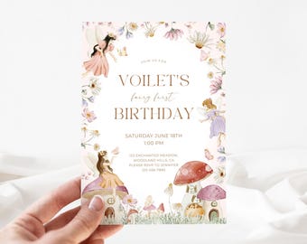 May include: A whimsical invitation for a fairy-themed first birthday. The design features watercolor illustrations of fairies, mushrooms, and flowers. The text reads "VOILET'S fairy first BIRTHDAY" with event details. The invitation is held by a hand.