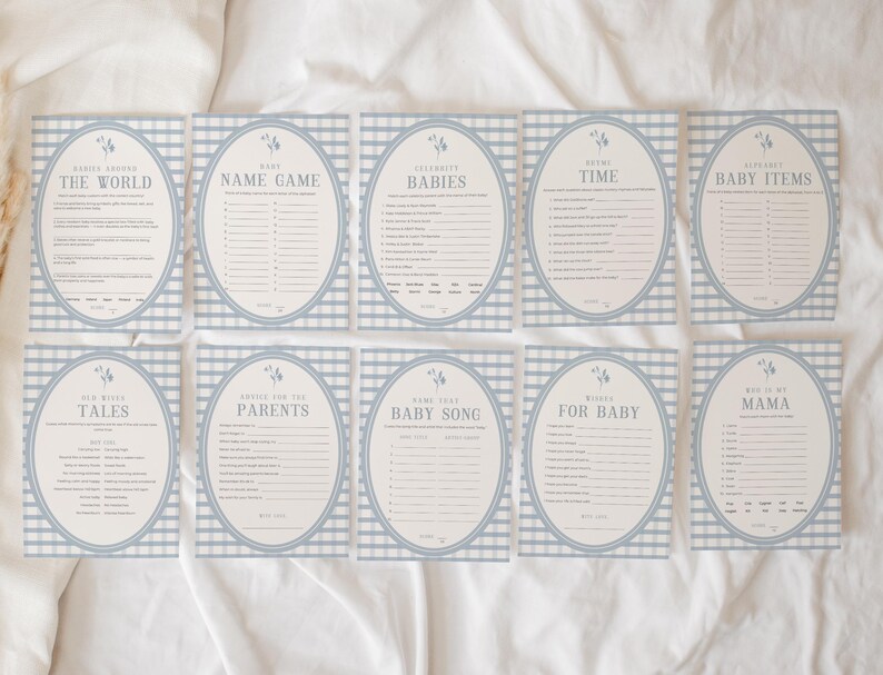 Op de afbeelding: Een set van tien babyshower-spelkaarten. Elke kaart heeft een blauw-wit geruite vichy-rand en een ovale lijst. De kaarten hebben titels als "De Wereld", "Naamspel" en "Babyartikelen".