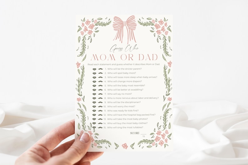 May include: A cream-colored baby shower game card with the text "Guess Who Mom or Dad". The card features a pink bow and floral border. The game includes questions to determine who will be the stricter parent.