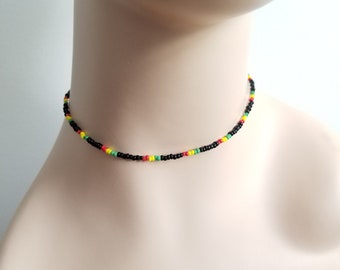 May include: A black beaded choker necklace with red, yellow, and green accents.