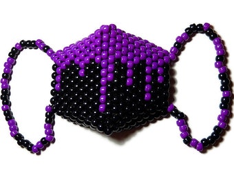 May include: A black and purple beaded face mask with a dripping design. The mask is made of small plastic beads and has a geometric shape.
