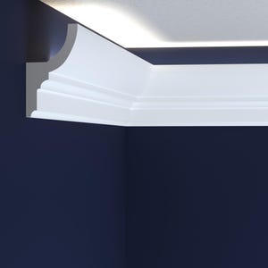 May include: A section of white crown molding installed in a corner where the ceiling meets the wall. The molding has a layered design with a curved top edge and is set against a dark blue wall and a white ceiling.