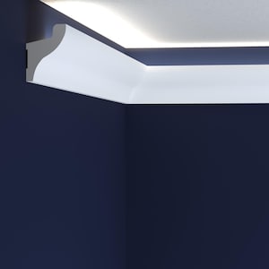 May include: White ceiling molding with a curved edge, installed in a corner of a room with a dark blue wall. The molding is illuminated by a strip of LED lights.