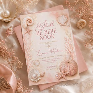 May include: A rectangular baby shower invitation card featuring a soft pink watercolor background with illustrations of seashells, starfish, and coral. The text reads Shell BE HERE SOON, JOIN US FOR A BABY SHOWER HONORING Lauren Holmes.