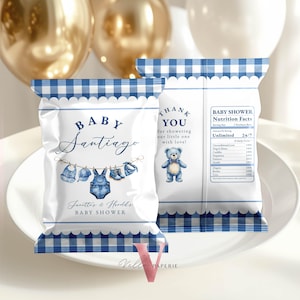 May include: Two white baby shower favor bags with blue gingham trim. One bag features the text "BABY Santiago" and baby clothes illustrations. The other bag says "THANK YOU" with a teddy bear illustration.