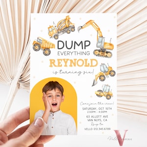 May include: A birthday party invitation featuring a child's photo and construction vehicles. The text reads "DUMP EVERYTHING REYNOLD is turning six!" with event details. The invitation is held by a hand.