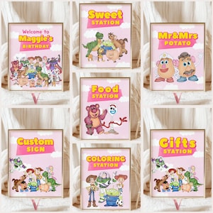 May include: A collection of seven rectangular signs with gold frames, featuring pink backgrounds, white clouds, and various cartoon characters from the Toy Story franchise. Each sign displays yellow text including Welcome to Maggie's Birthday, Sweet Station, Mr & Mrs Potato, Food Station, Custom Sign, Coloring Station, and Gifts Station.