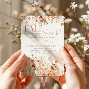 May include: Fall in love bridal shower invitation with a watercolor floral design in shades of orange, pink, and green. The invitation features the text "Fall in love" with a heart and the date "Saturday, November 21st at 2:00 PM".