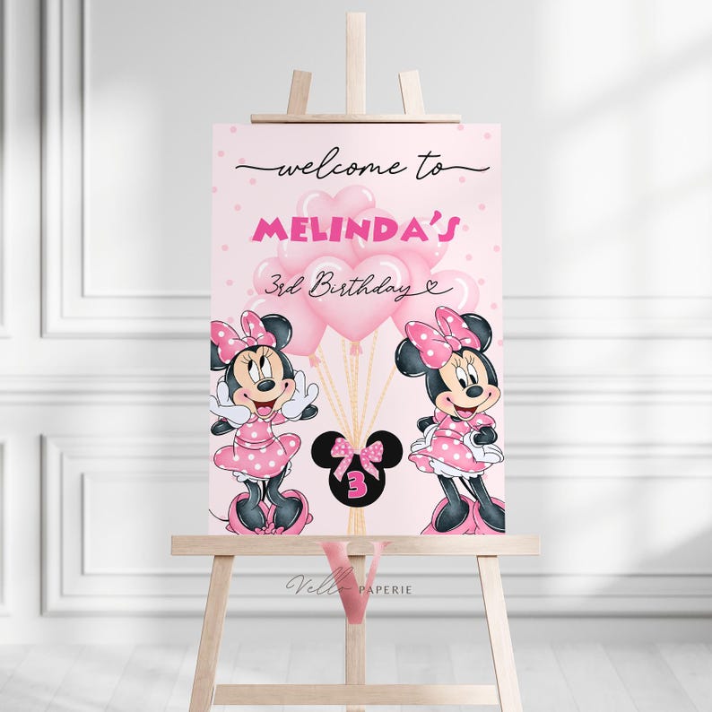 May include: A pink birthday welcome sign featuring Minnie Mouse illustrations. The sign reads "welcome to Melinda's 3rd Birthday" and includes pink balloons. The sign is displayed on a wooden easel, suitable for a third birthday party.