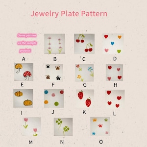 Peut inclure: Plusieurs plaques &agrave; bijoux carr&eacute;es avec divers motifs. Les motifs incluent des cerises, des c&oelig;urs, des champignons, des empreintes de pattes, des fleurs, des fraises et des citrouilles. Le texte "Jewelry Plate Pattern" est en haut.