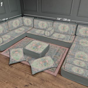 May include: U-shaped sectional sofa set with floral patterned upholstery in shades of blue, pink, and green. Includes a matching ottoman, rug, and throw pillows. The sofa measures 130 inches / 330 cm wide and 75 inches / 190 cm deep.