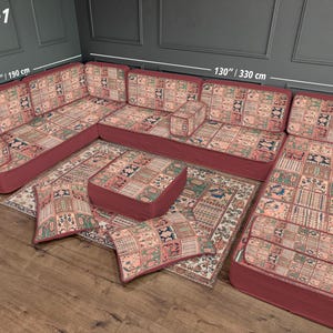 Könnte beinhalten: U-förmiges Ecksofa-Set mit gemustertem Stoff in Rot-, Beige- und Grüntönen. Das Set umfasst ein großes Sofa, eine Ottomane und Wurfkissen. Das Sofa ist 330 cm lang und 190 cm breit, mit einer Tiefe von 70 cm.