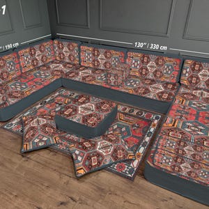 May include: U-shaped sectional sofa set with a patterned rug and ottoman. The sofa is dark teal with a patterned fabric in red, brown, and cream. The set measures 130 inches (330 cm) wide and 75 inches (190 cm) deep.
