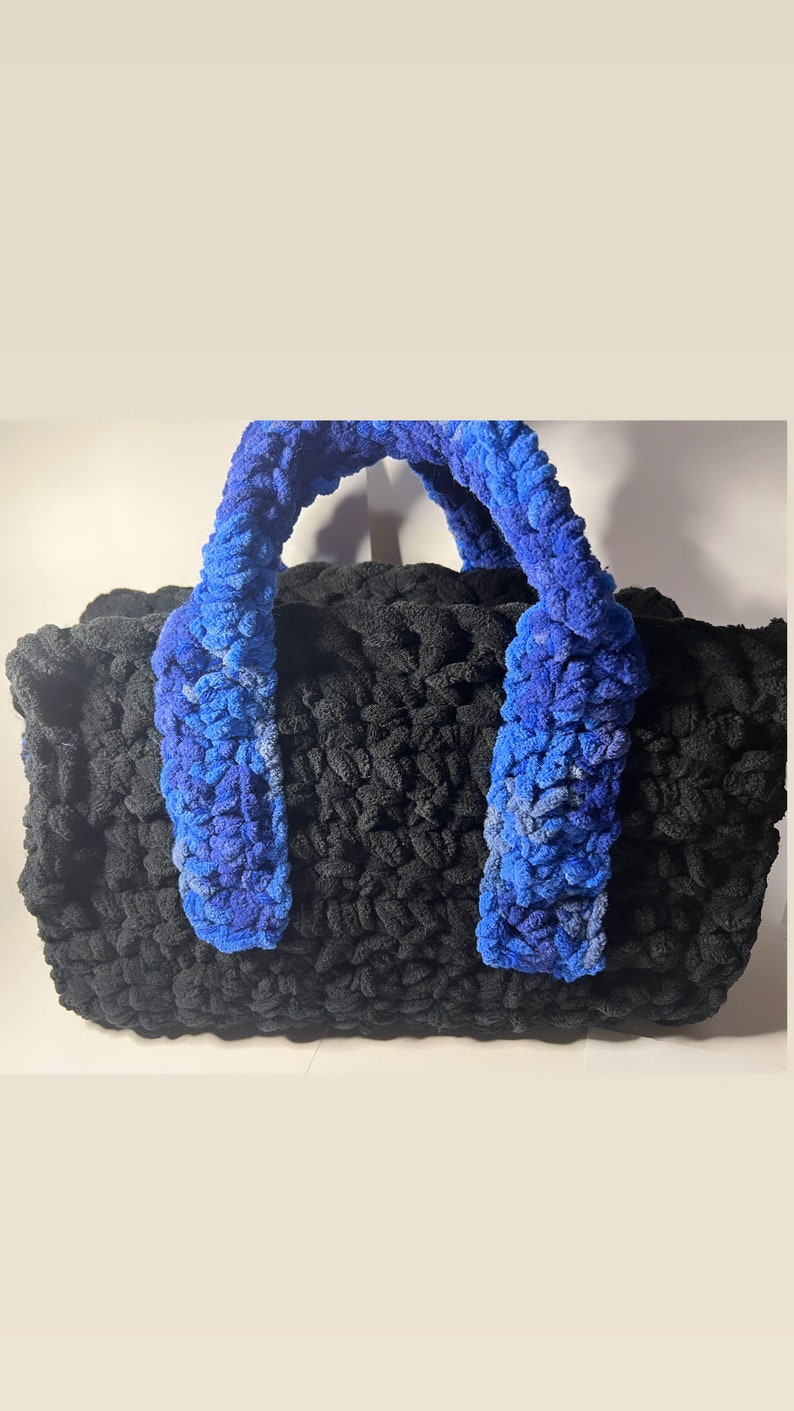 May include: A black crocheted tote bag with blue crocheted handles.