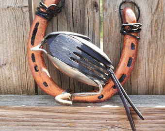 Handmade recycled silverware horse shoe bord on a wire