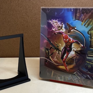 May include: A black plastic display stand with a clear acrylic case for a collectible figure. The case features a colorful image of Spider-Man in a red and blue suit, swinging through a city skyline.