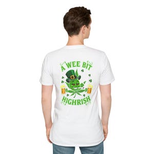 May include: White t-shirt with a green graphic featuring a cannabis leaf with a leprechaun hat, a smiling face, and the text "A Wee Bit Highrish". Two mugs of beer and shamrocks complete the design.