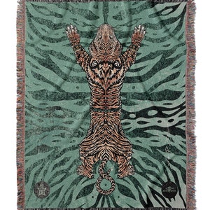 May include: A woven tapestry featuring a tiger with a green and brown striped background. The tiger is depicted in a standing position with its arms raised above its head.