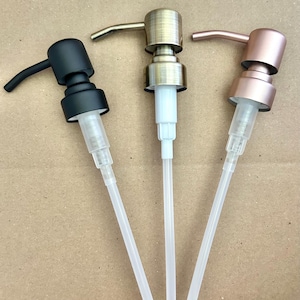 May include: Three soap dispenser pumps in black, antique brass, and rose gold. Each pump has a curved spout and a clear plastic tube. The pumps are displayed against a neutral background.