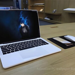 May include: A white laptop computer with a black keyboard and trackpad. The laptop screen displays an anime-style wallpaper featuring a blue-haired character with blue flames in the background. The laptop is on a wooden desk with a black mousepad, a white wireless mouse, and a smartphone.