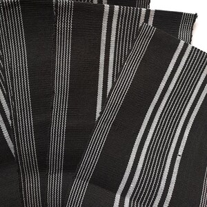 May include: A stack of black and white striped fabric, likely for sewing or crafting projects.
