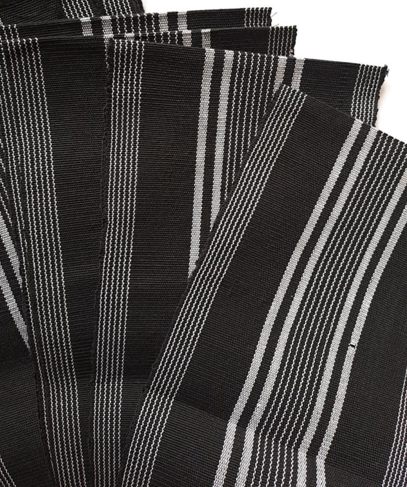 May include: A stack of black and white striped fabric, likely for sewing or crafting projects.