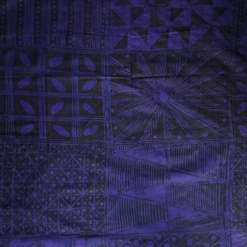 May include: A close-up of a fabric with a repeating geometric pattern in shades of purple and black. The design includes squares, triangles, and sunburst shapes. The fabric appears to be textured.