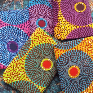 May include: A collection of colourful fabric with a circular pattern. The fabric is a mix of blue, yellow, red, purple, and brown.