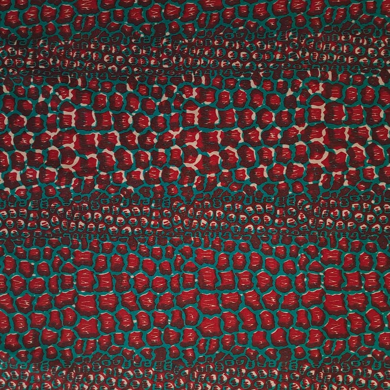 May include: Red and teal fabric with a repeating pattern of small, irregular shapes. The pattern resembles a crocodile skin.