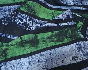 May include: A fabric with a batik-style pattern. The design features broad, horizontal stripes in black, green, and blue-gray. The green stripes have a mottled appearance, while the blue-gray stripes have a textured, almost wood-grain look. The fabric is likely used for clothing or home decor.