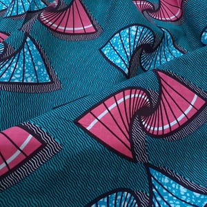 Op de afbeelding: Close-up van een turquoise stof met een herhaald patroon van roze en blauwe waaierachtige vormen. De stof heeft een getextureerde, golvende achtergrond. De waaier vormen zijn zwart en wit omlijnd.