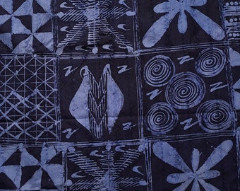 May include: A dark blue fabric with a repeating pattern of squares. Each square contains a different design in a lighter blue, including floral, geometric, and spiral motifs. The fabric has a textured appearance.