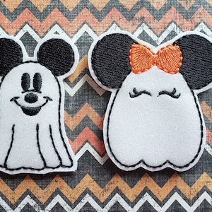 May include: Two white felt ghost ornaments with embroidered black eyes, mouths, and Mickey Mouse ears. One ghost has a red bow.