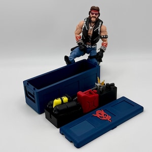 May include: A blue plastic storage box with a red logo and a smaller blue box with a red logo. The smaller box is open and contains a yellow and black scuba tank, a red petrol can, and other items.