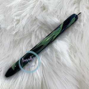 May include: A black and green pen with a marbled design. The pen has a silver clip and a black tip.