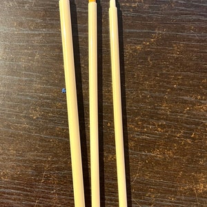 May include: Three paint brushes with wooden handles and natural bristles. The brushes are different sizes, with the largest brush on the left and the smallest brush on the right.
