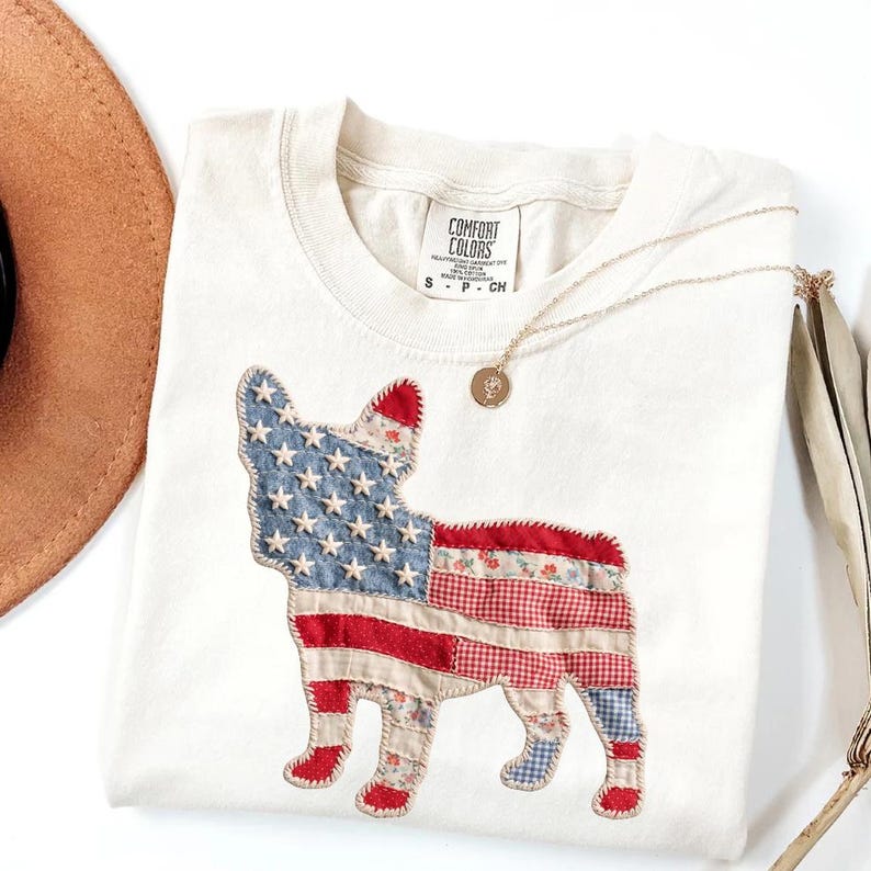 Ivory Comfort Colors patriotic French Bulldog patchwork t-shirt for women, featuring a large quilted Frenchie silhouette with embroidered white stars, denim blue, red gingham, cream floral, and striped fabric — 4th of July Frenchie mom gift, American flag French Bulldog tee, dog mom patriotic shirt, patchwork Frenchie Comfort Colors tee, French Bulldog lover gift idea.