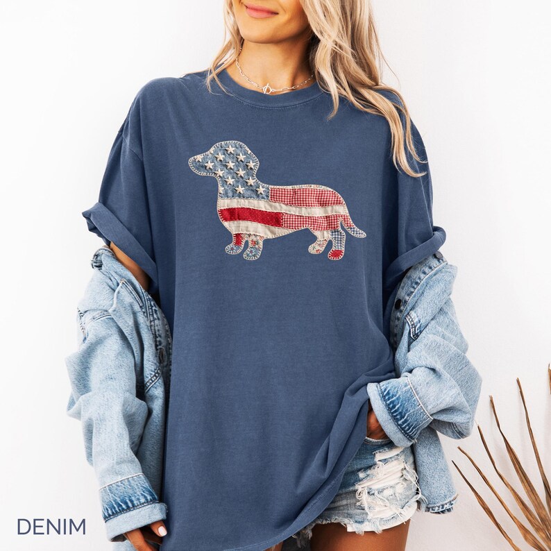 Denim Comfort Colors patriotic dachshund patchwork t-shirt for women, featuring a large quilted wiener dog graphic with embroidered white stars, denim blue, red gingham, cream floral, and striped fabric — 4th of July dachshund mom gift, American flag wiener dog tee, cute dog mom patriotic shirt, patchwork dachshund Comfort Colors tee, dachshund lover gift idea.