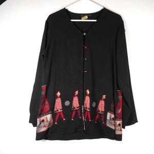 May include: A black long-sleeved cardigan with a V-neckline and four front buttons. The lower section features a graphic print of figures in red and white patterned tunics and red leggings, interspersed with red vase-like shapes and circular motifs.
