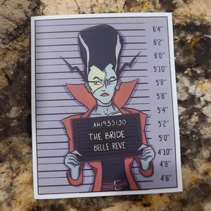 Könnte beinhalten: Eine Schwarzweiß-Illustration im Stil eines Polizeifotos einer weiblichen Monsterfigur mit grüner Haut, schwarzen Haaren und rotem Lippenstift. Das Monster trägt eine rote Jacke und hält ein Schild mit der Aufschrift "AH1935130 THE BRIDE BELLE REVE".