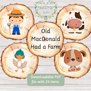 May include: Four wooden circles with illustrations of a farmer, a cow, a duck, and a dog. The text "Old MacDonald Had a Farm" is written on one of the circles.
