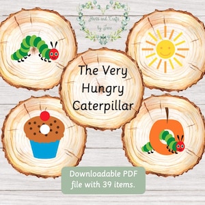 May include: Five wooden circles with illustrations from The Very Hungry Caterpillar book. The circles feature a caterpillar eating an apple, a caterpillar eating a piece of cake, a caterpillar eating an orange, a sun, and a caterpillar eating a leaf.
