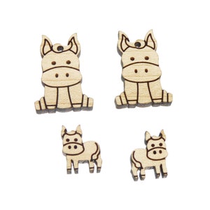 May include: Four wooden cutouts of a cow, two large and two small. The cow cutouts are brown and have black outlines.