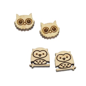 May include: Set of four wooden owl ornaments. Two owls have a simple design with large eyes, while the other two owls have a more detailed design with wings and a branch.