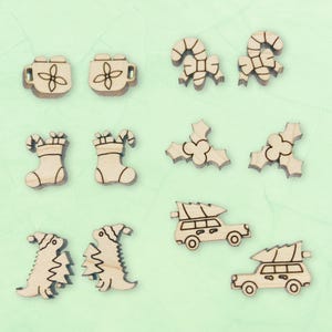 May include: A set of 10 wooden Christmas ornaments featuring various holiday themes, including candy canes, stockings, holly, and Christmas trees. The ornaments are unpainted and ready to be decorated.