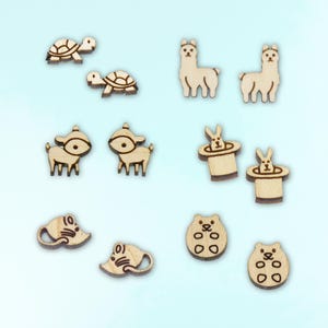 May include: A set of 12 wooden laser cut shapes, including a llama, a turtle, a deer, a rabbit in a hat, a mouse, and a cookie. The shapes are all in a natural wood color.