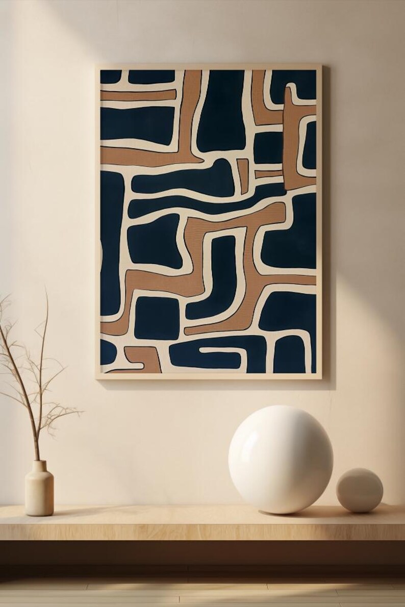May include: Abstract art print with a geometric pattern in shades of brown and blue. The print is framed and hanging on a wall.