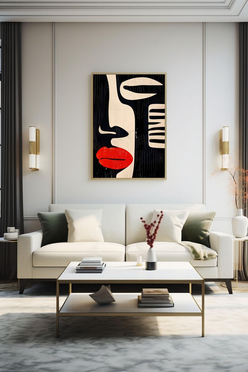 May include: A white couch with green pillows sits in front of a black and white abstract art print of a face with red lips. The couch is in a room with a white coffee table and a rug.